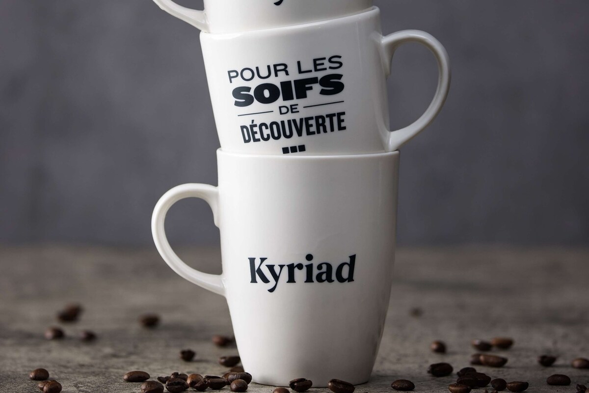 Tres tazas blancas de café apiladas con texto.