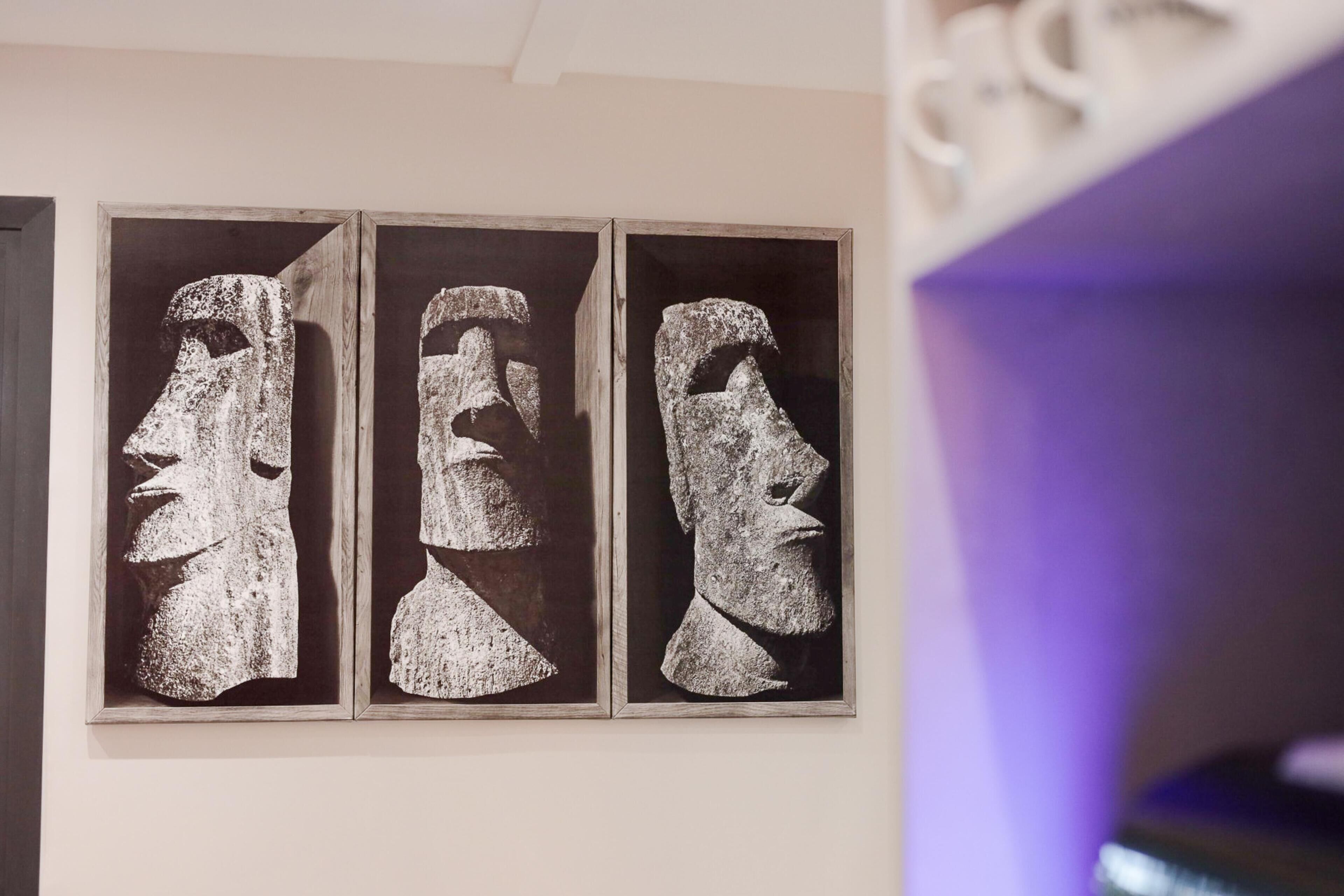 Tres tallas de piedra en una pared.