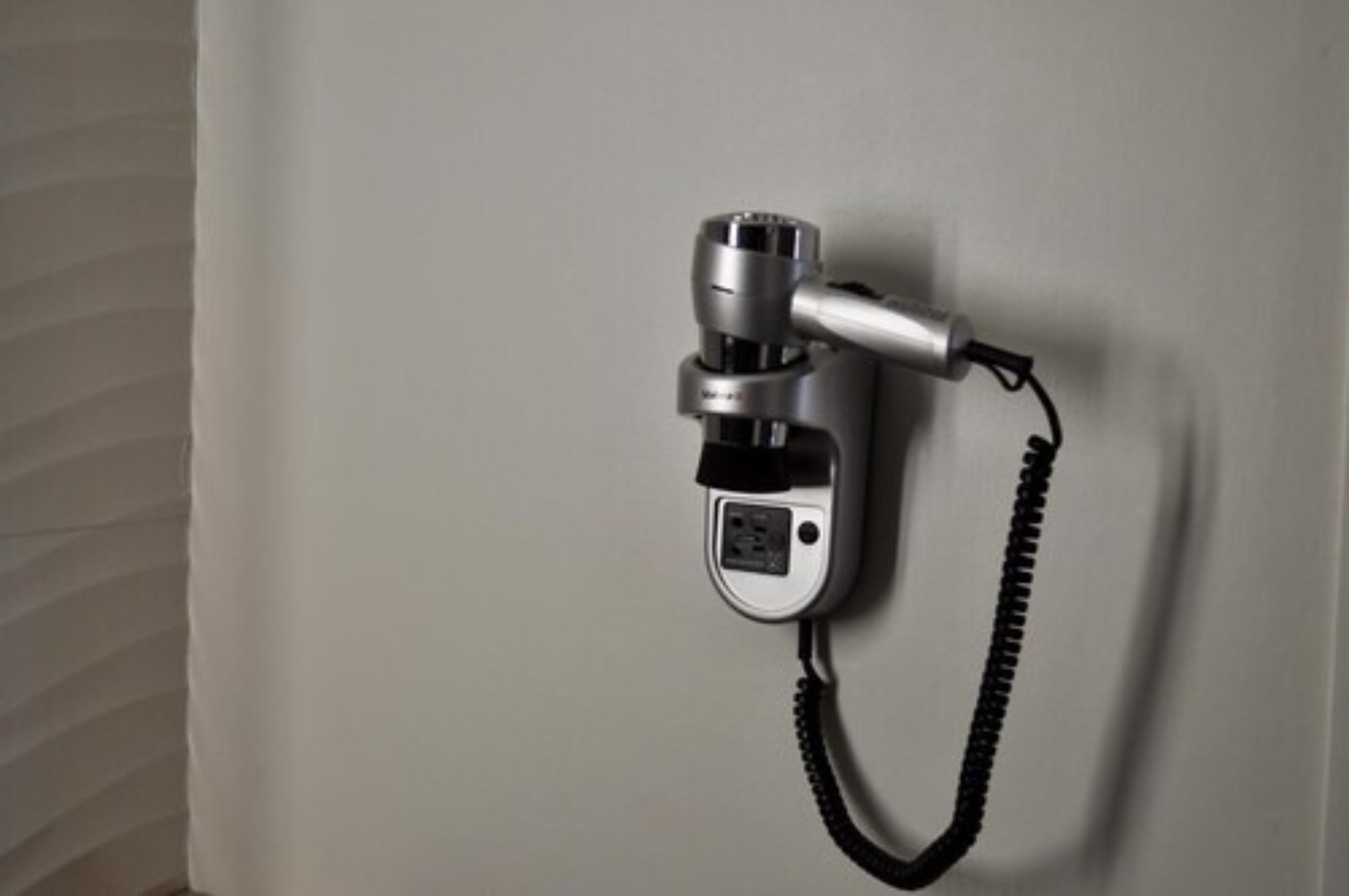 Un teléfono de pared con cable en espiral.