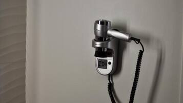 A wall-mounted telephone with a coiled cord.