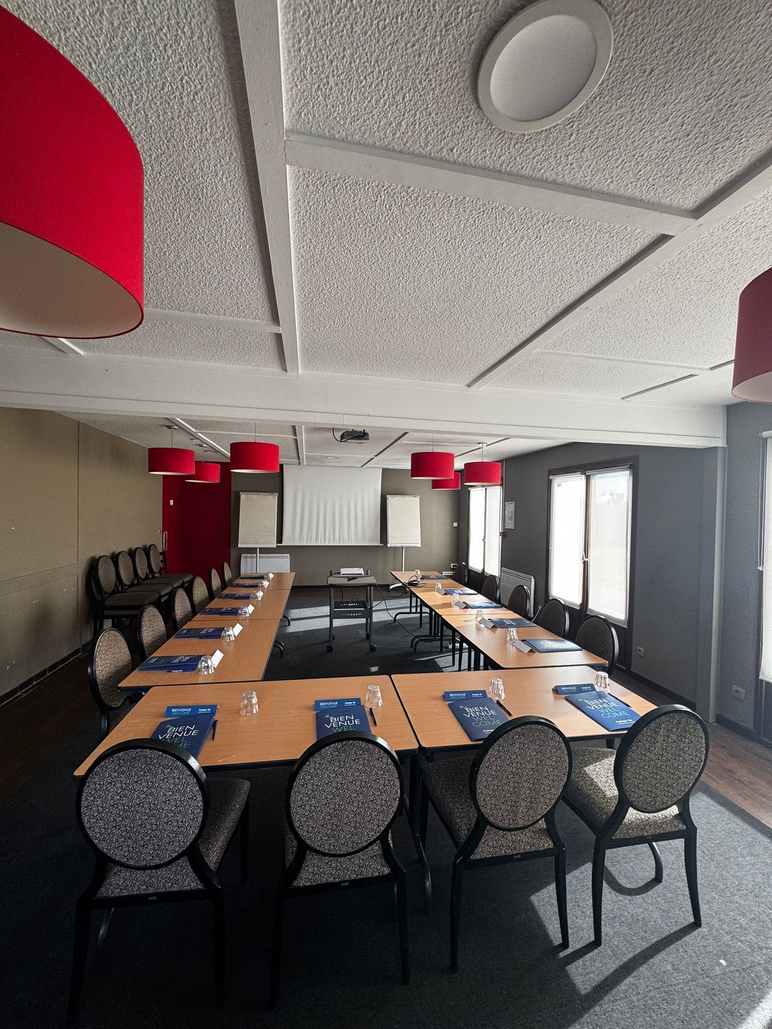 Une salle de conférence avec une longue table, des chaises et un éclairage d’ambiance rouge.