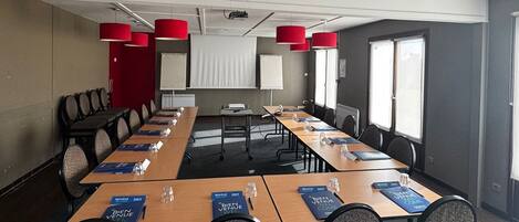 A conference room with a long table, chairs, and red accent lighting.