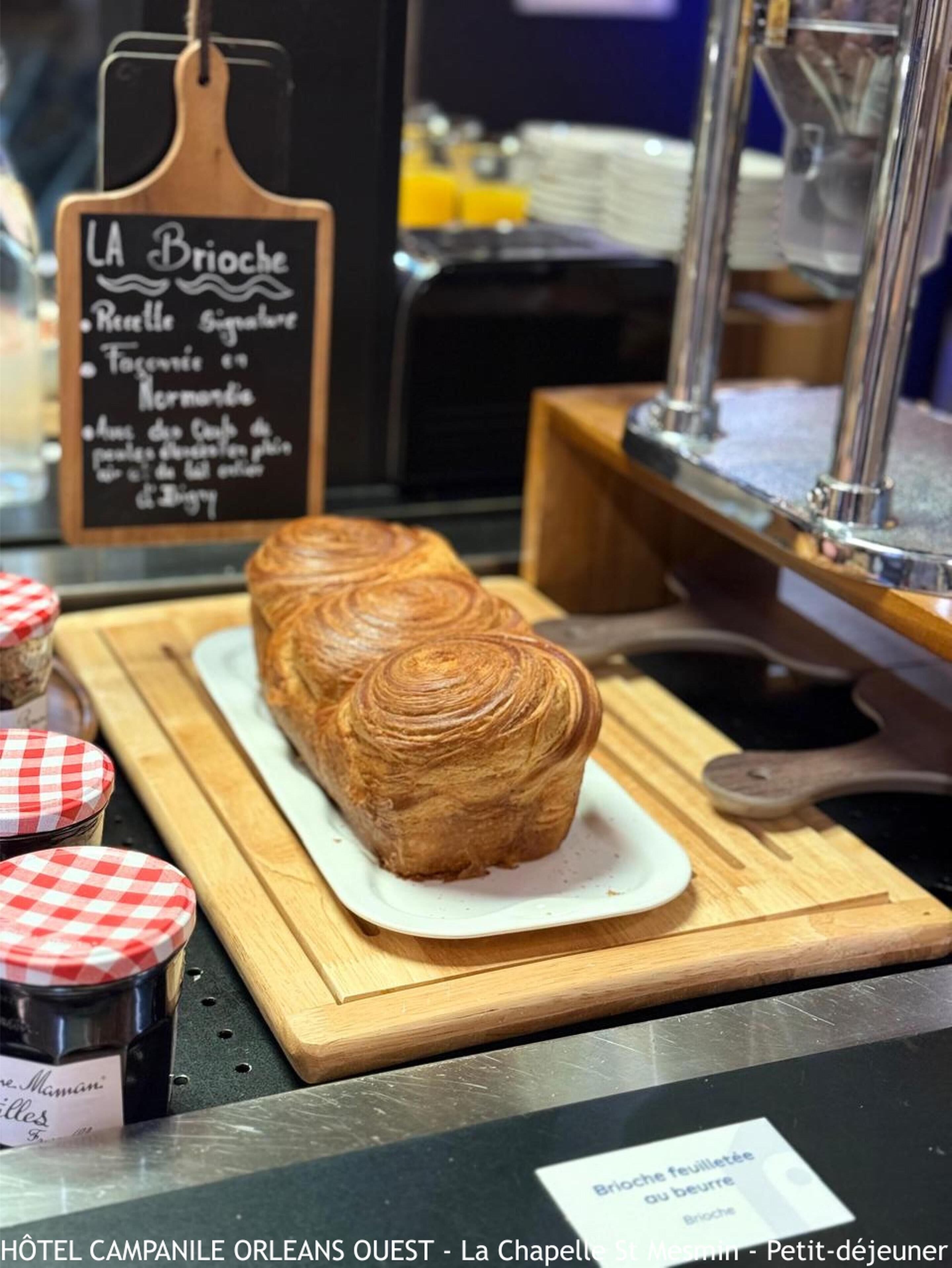 A bakery display with a sign reading 'LA Brioche' and a loaf of brioche bread on a wooden board.