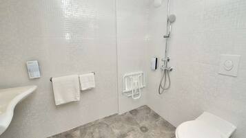 Un baño moderno con ducha, inodoro y perchero.