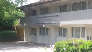 A two-story building with a flat roof and a balcony on the upper floor.