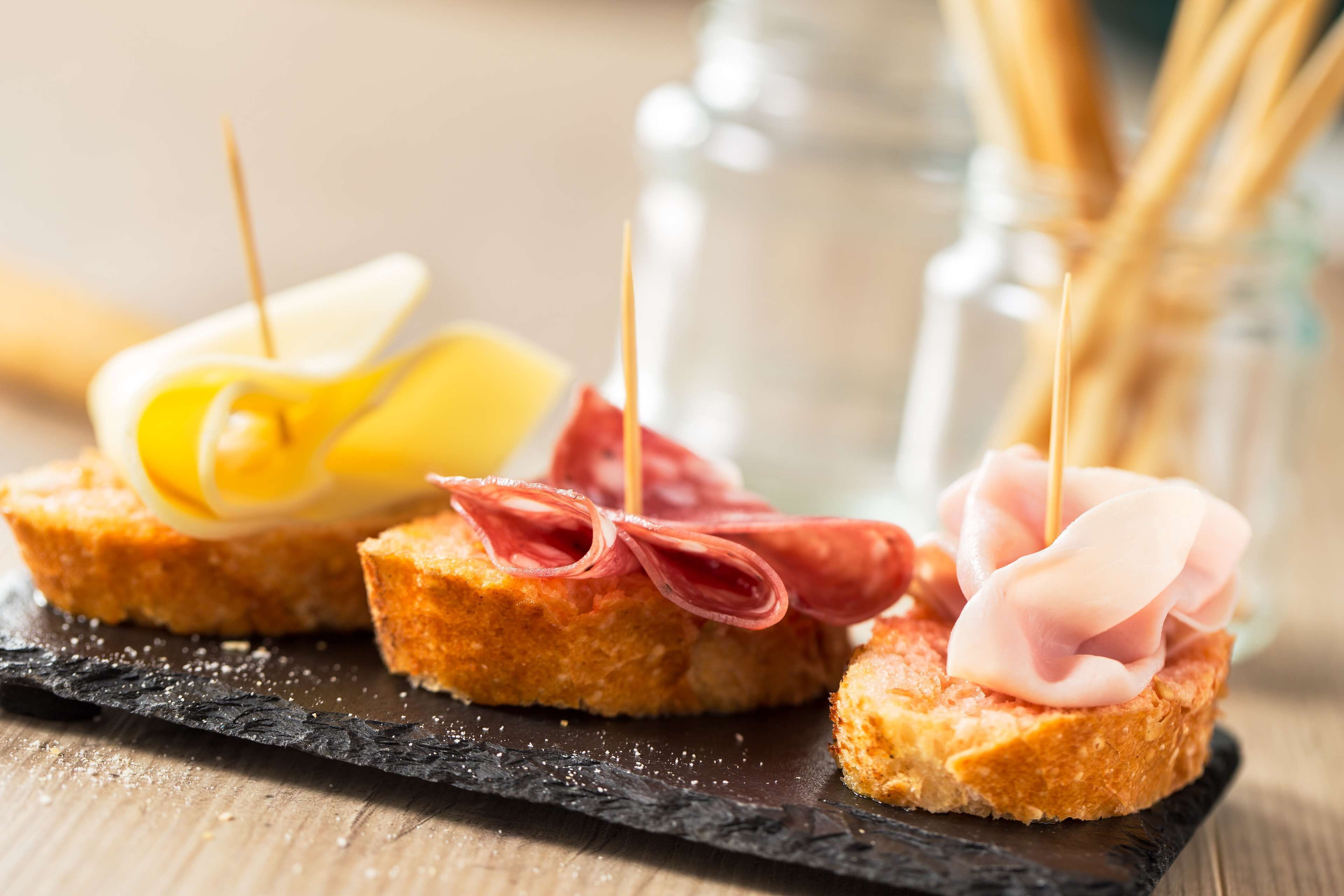 Three appetizers on a black slate plate.