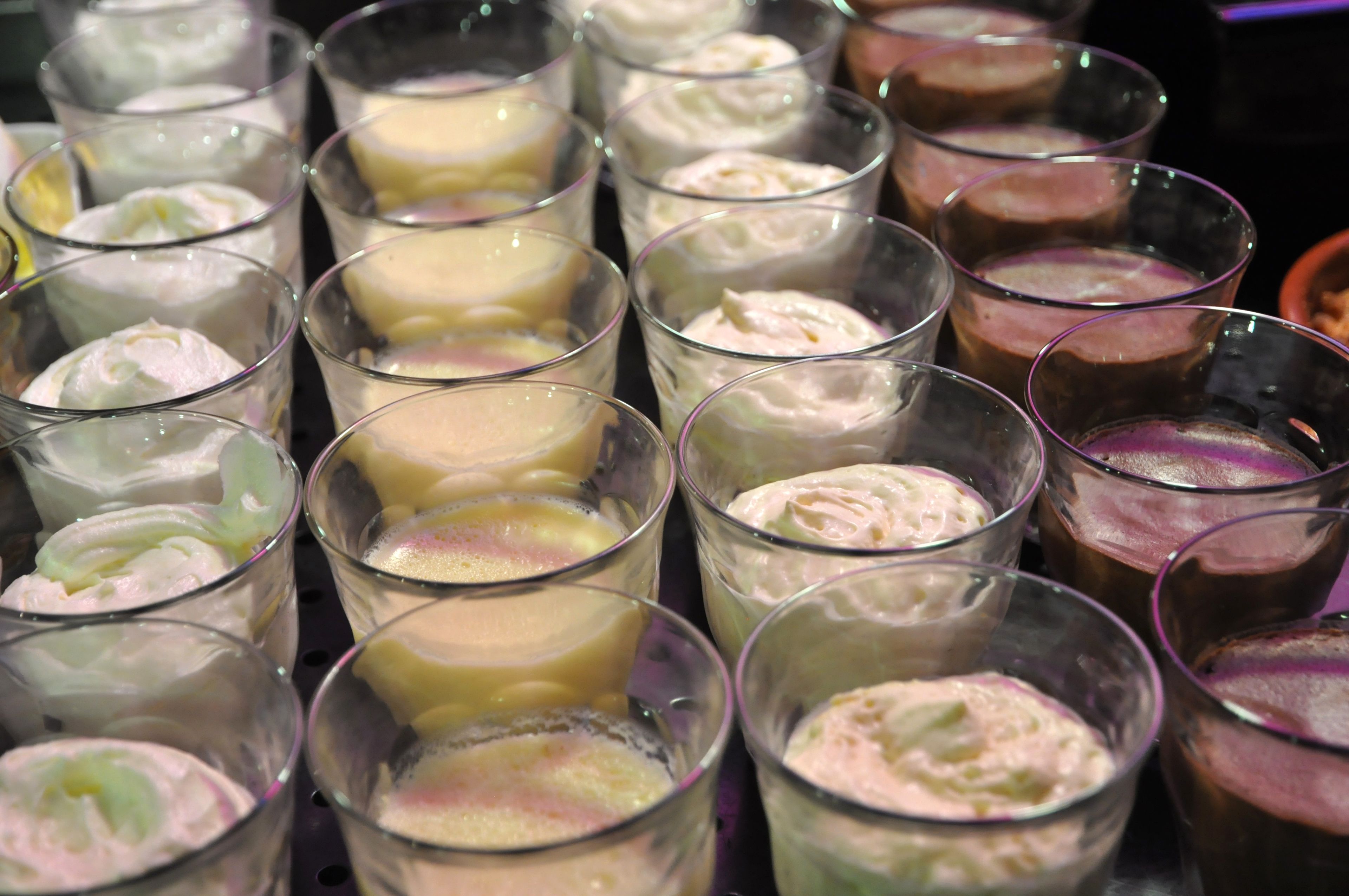 A variety of dessert glasses arranged on a tray.