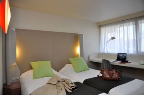 A hotel room with two beds, a desk with a laptop, a window with curtains, and a lamp. - Hôtel Inn Design & Restaurant Nantes (Sainte-Luce-sur-Loire)
