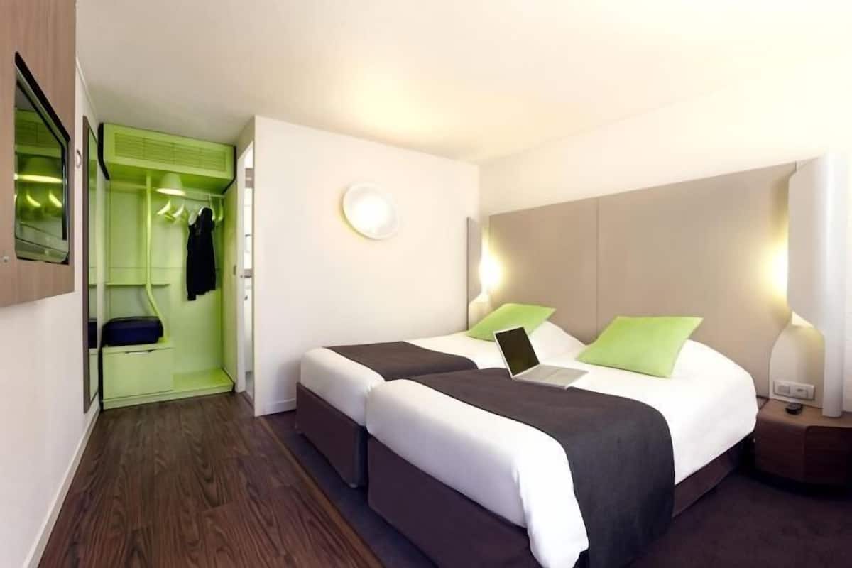 A hotel room with a bed, bedside table, and a walk-in closet.