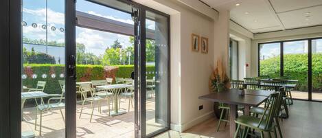 Un comedor moderno en interior con puertas de vidrio que dan a un patio exterior.