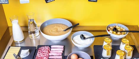 Un bufé de desayuno con diversas opciones de alimentos y salsas.