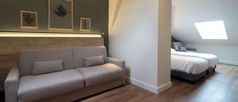 Una habitación moderna con sofá, cama y tragaluz.