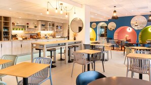A modern cafe with a central bar area, seating arrangements, and decorative mirrors.