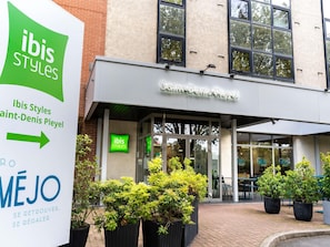 The exterior of ibis Styles Saint-Denis Pleyel hotel with a sign indicating the location. - ibis Styles Paris Saint Denis Pleyel (Saint-Denis)
