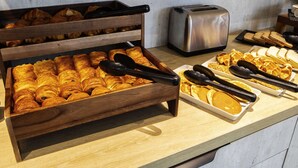 Ein Frühstücksbuffet mit Croissants, Waffeln und Brot.