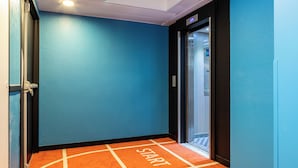 A hallway with a blue wall and an orange carpet with 'START' written on it.
