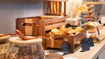A bakery display with various baked goods and a sign indicating a cake.
