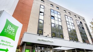 Ein Gebäude mit einem Schild für 'ibis Styles' und 'Saint-Denis Pleyel'.