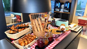 A buffet setup with various baked goods, condiments, and a coffee machine. - Campanile Orleans Saran (Saran)