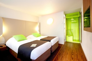 A hotel room with two beds, a green shower area, and a wooden floor. - Campanile Orleans Saran (Saran)