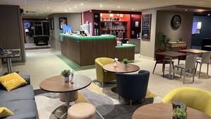 A modern lobby with a reception desk, seating area, and pool table. - Campanile Orleans Saran (Saran)