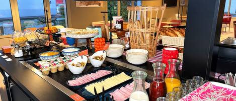 Een buffet met diverse gerechten en bijbehorende sauzen.
