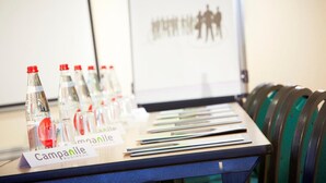 A conference table with name tags, water bottles, and brochures. - Campanile PRIME - Paris Bobigny (Bobigny)