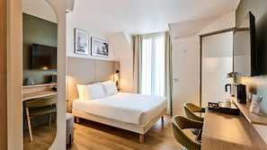 A hotel room with a bed, a desk, a chair, a television, and a window with curtains. - Campanile PRIME - Paris 14 Maine Montparnasse (Paris)