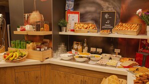A breakfast buffet with various food items, including fruits, pastries, and bread. - ibis Clichy Centre Mairie (Clichy)