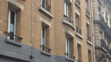 Un hotel con fachada de ladrillo, varios balcones y un cartel que indica que es un hotel ibis.