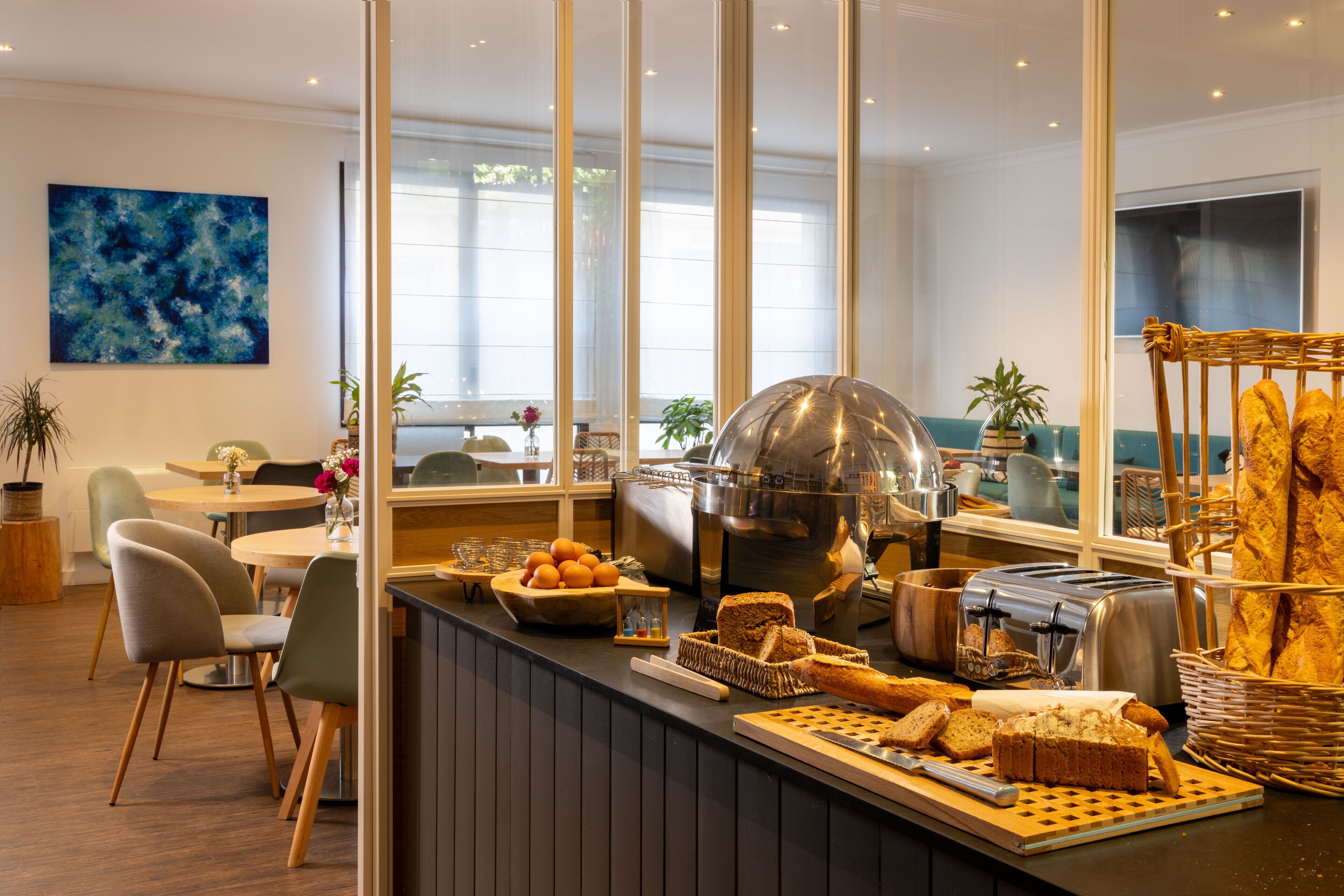 A breakfast bar with bread, pastries, and a coffee machine.