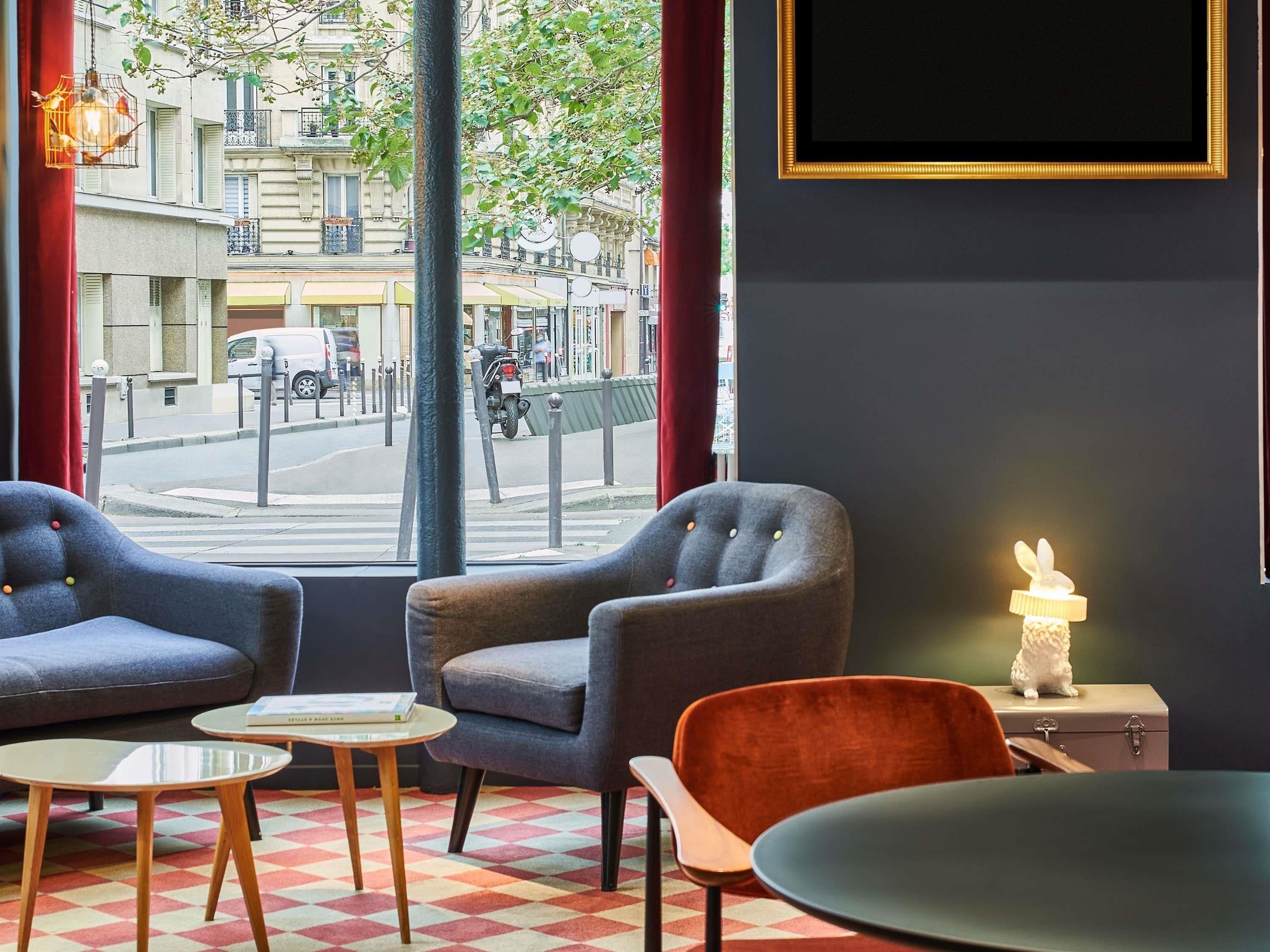 Een modern interieur met twee fauteuils, een tafeltje en uitzicht op de straat.