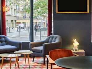 Een modern interieur met twee fauteuils, een tafeltje en uitzicht op de straat.