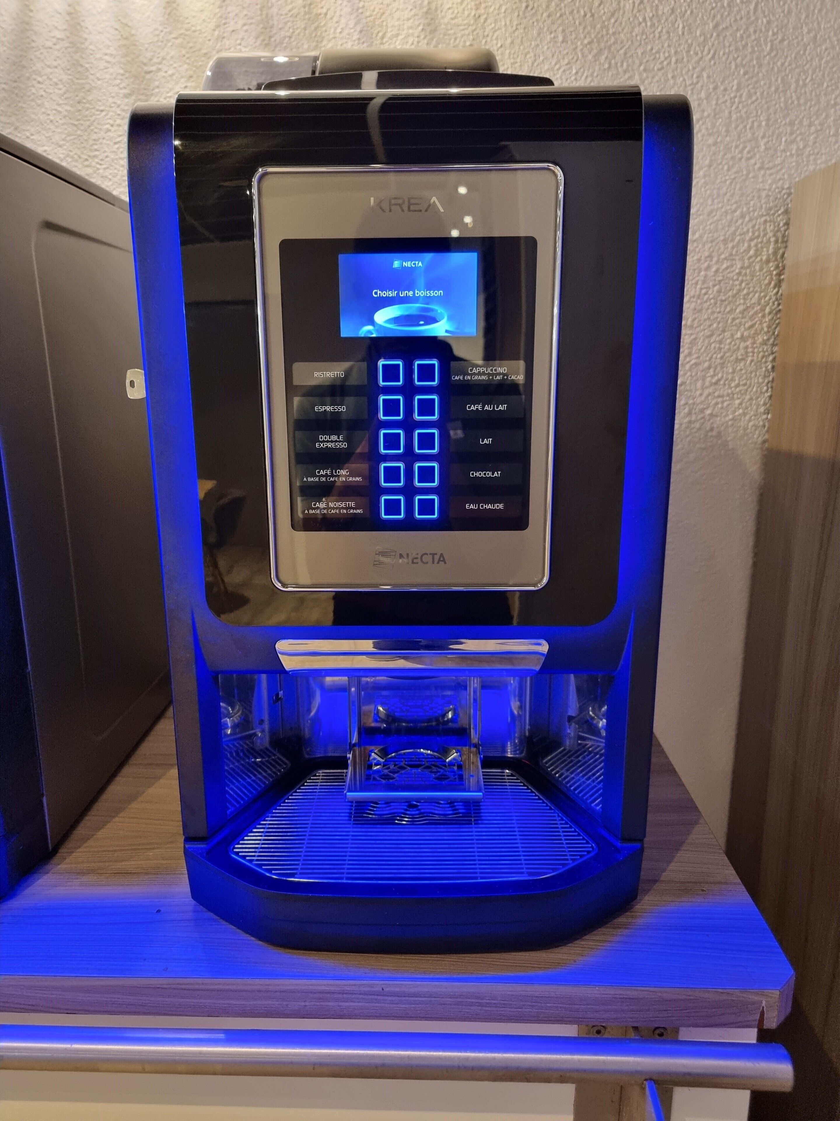 Una máquina de café con pantalla digital, depósito de agua y bandeja de goteo.