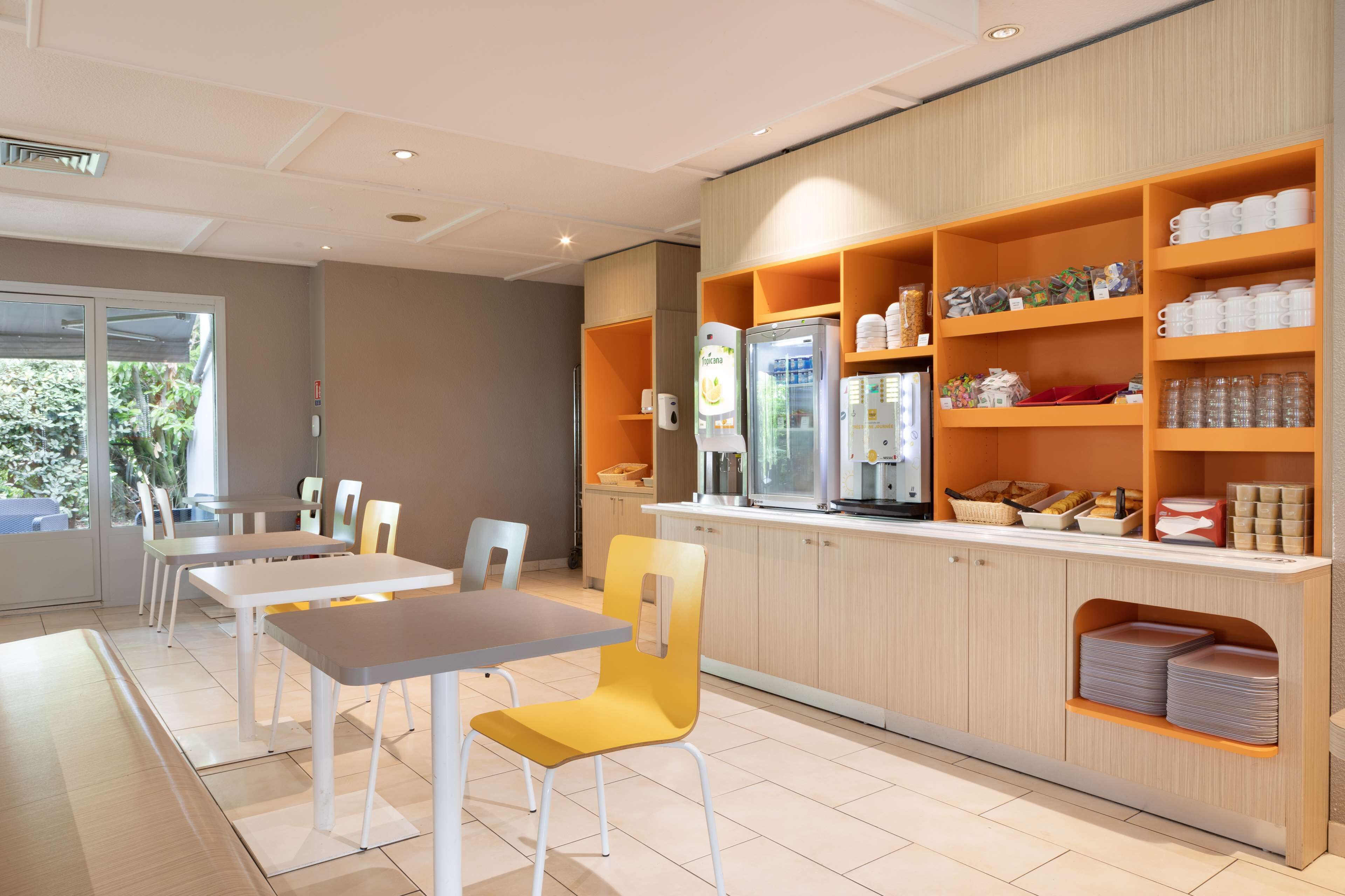 Una cafetería moderna con mostrador, zona de estar y estanterías con productos.