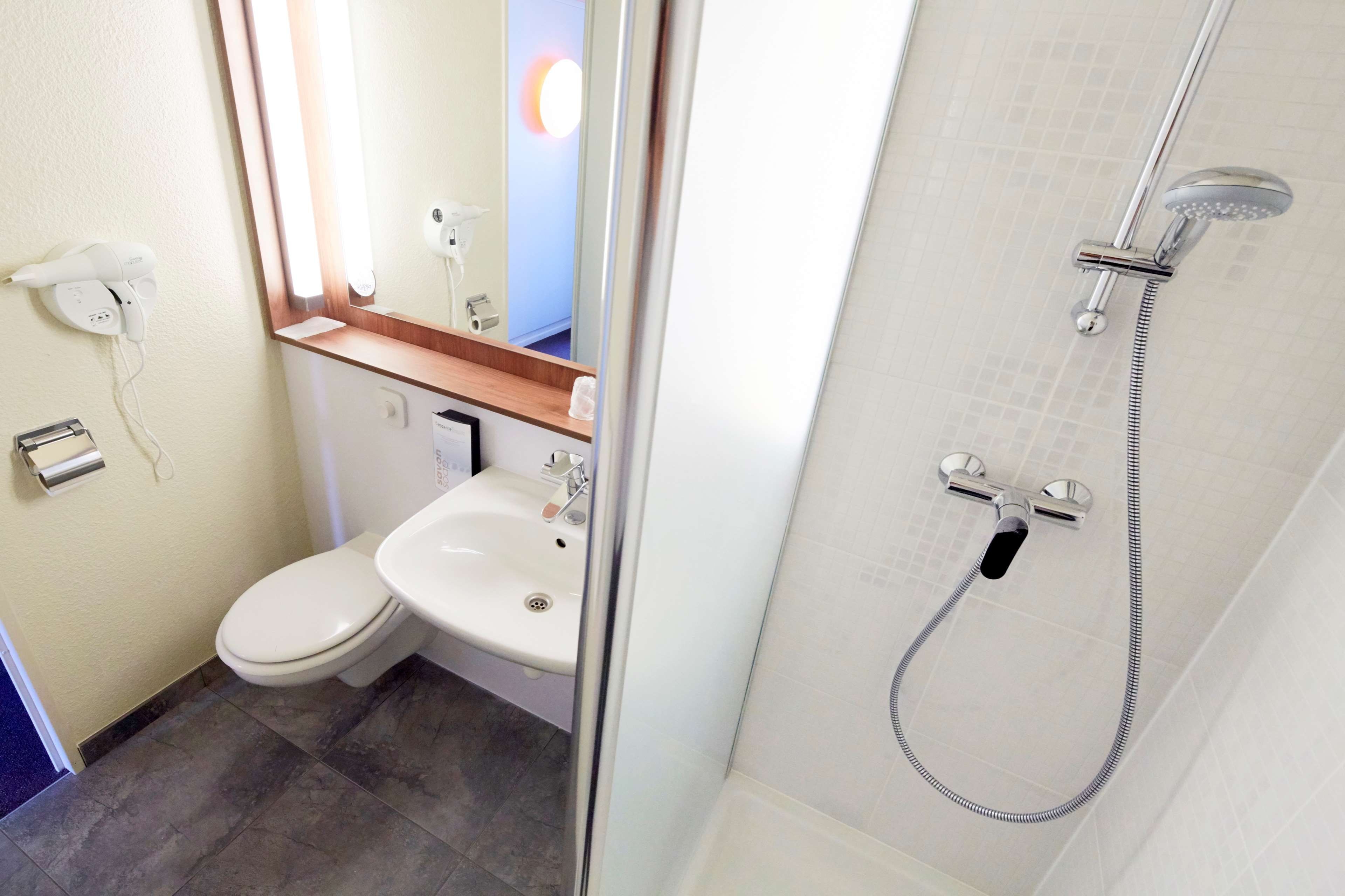 A bathroom with a toilet, sink, and shower.
