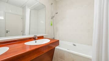 Ein Badezimmer mit zwei Waschbecken, einer Badewanne und einer Dusche.