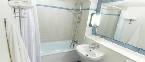A bathroom with a bathtub, a sink, and a mirror.