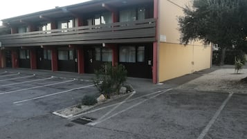 Ein mehrstöckiges Gebäude mit Parkplatz davor.