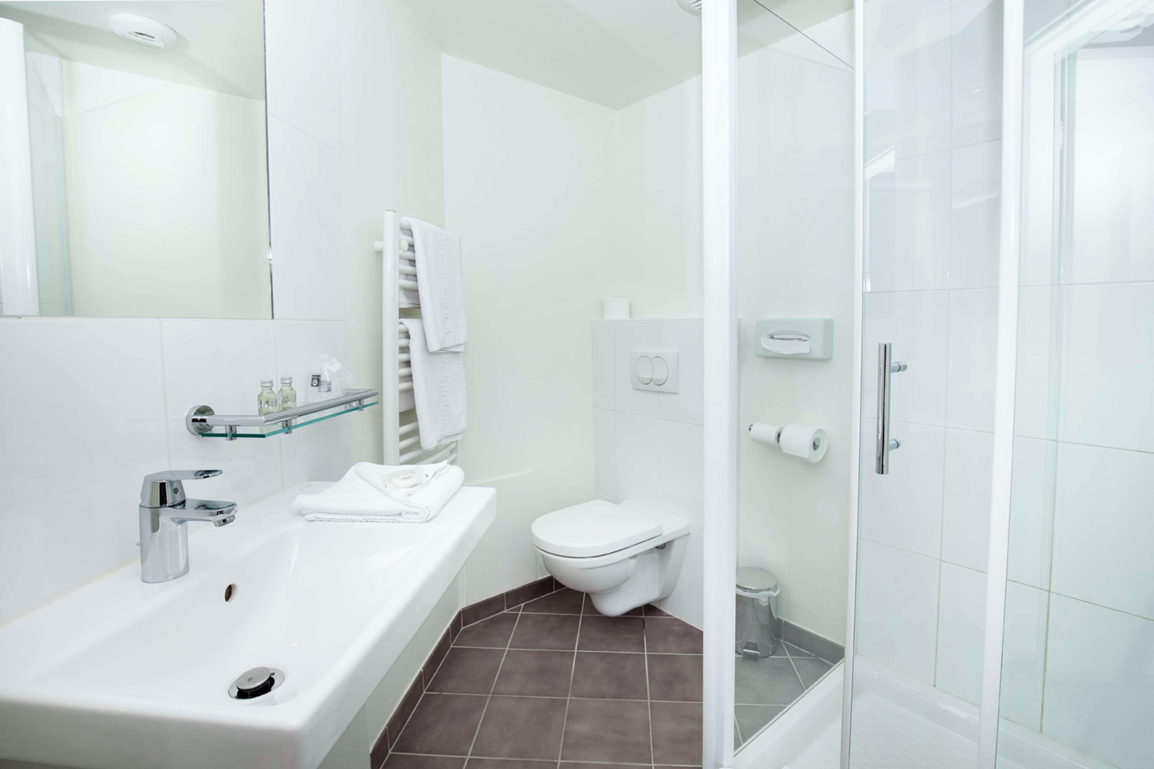 Un baño moderno con bañera, inodoro y ducha con cerramiento de vidrio.