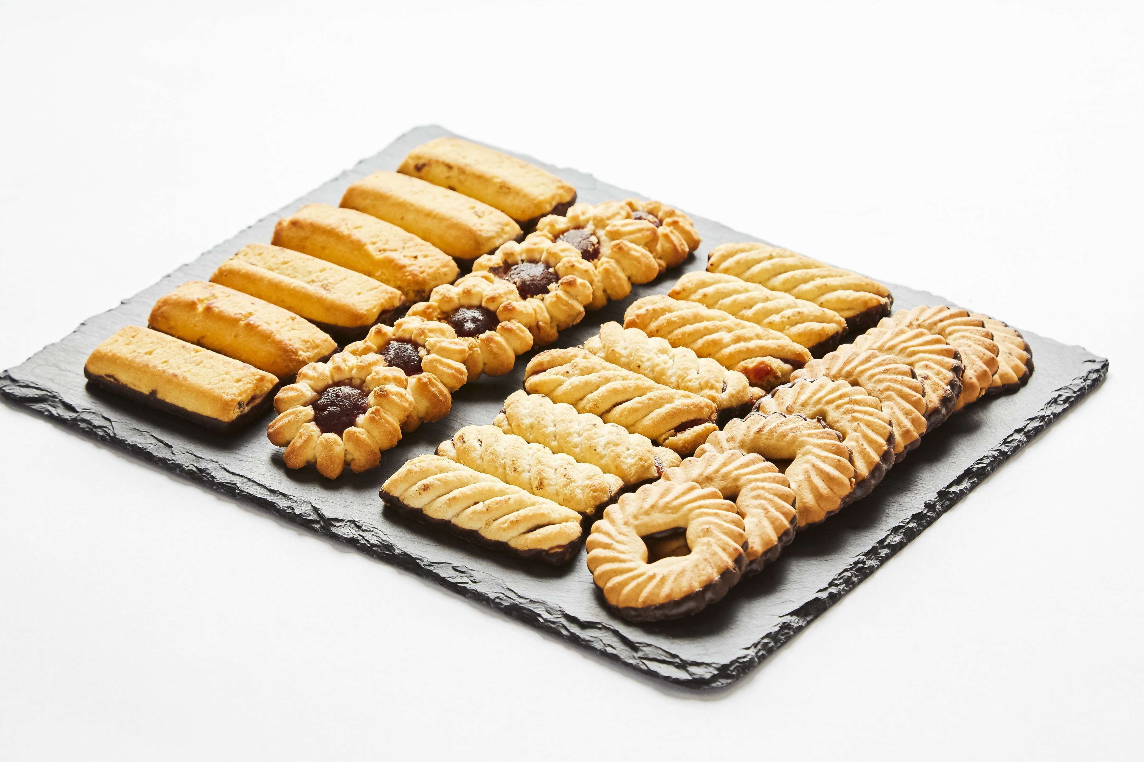 A tray of assorted cookies arranged on a slate board.