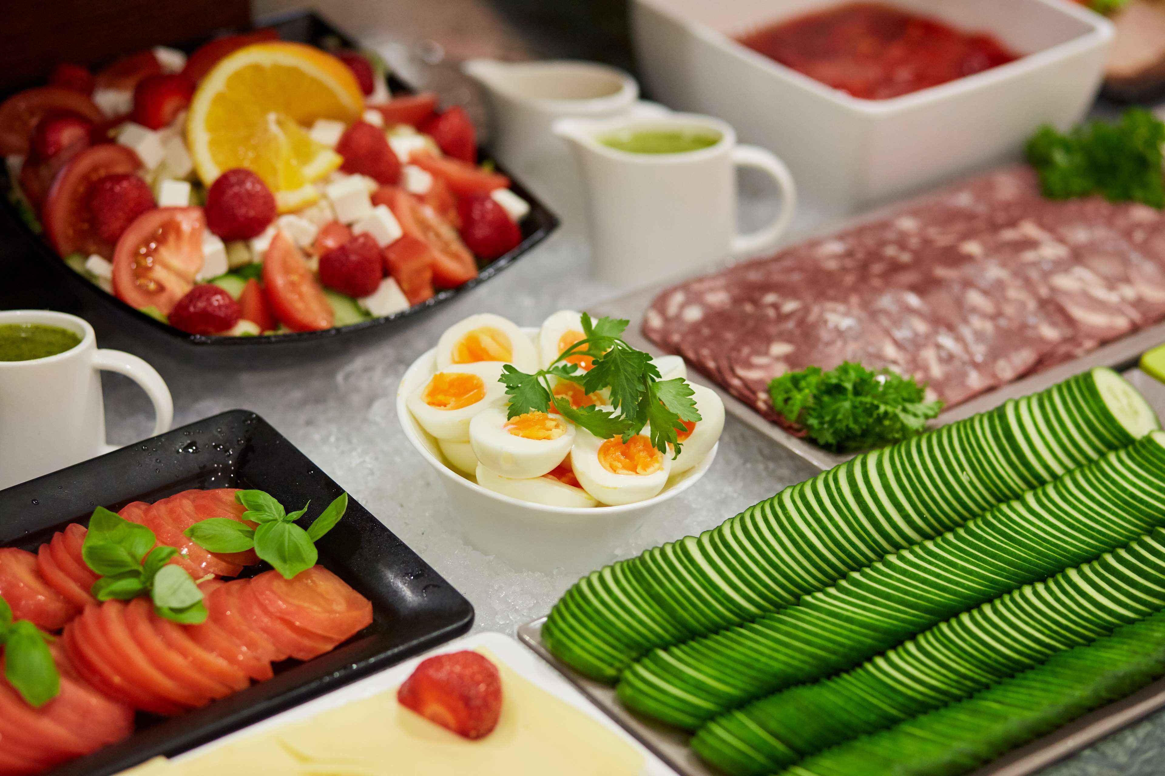 Diversos alimentos como rodajas de tomate, huevos y carne dispuestas sobre una mesa.