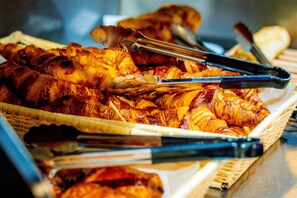 Una cesta con alimentos, incluyendo carne a la parrilla y productos de pastelería.