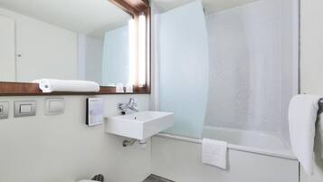 Ein modernes Badezimmer mit Waschbecken, Spiegel und Badewanne in Weiß.