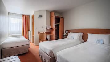 Una habitación de hotel con dos camas, un escritorio, una silla y un armario.