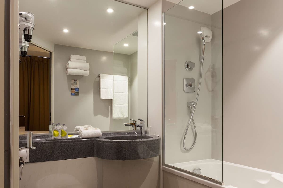 A modern bathroom with a toilet, sink, and shower.