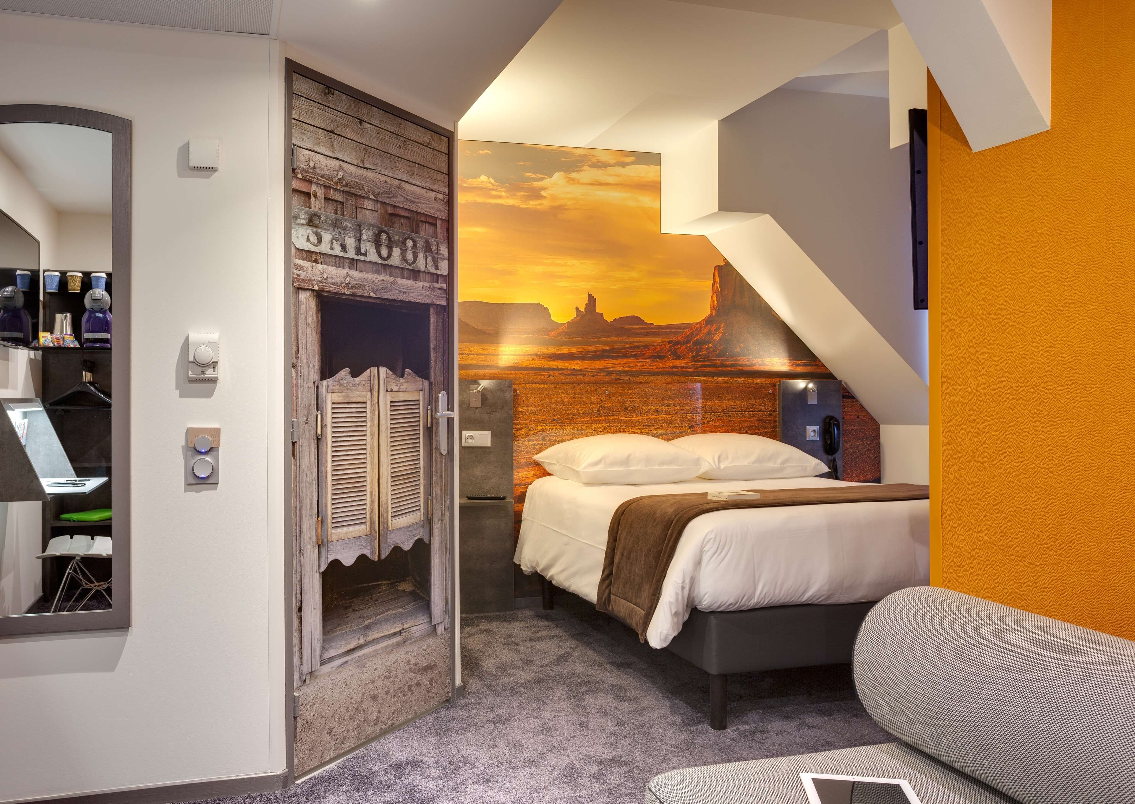 Un dormitorio con cama, escritorio, armario y baño.