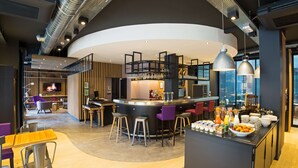 Un área de bar moderna con una barra curva, taburetes y una variedad de bebidas.