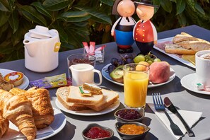 A breakfast table with croissants, toast, fruit, and a coffee pot. - Kyriad Direct Strasbourg Ouest - Zénith (Strasbourg)