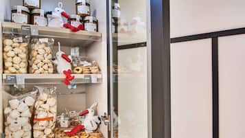 Een koelvitrine met diverse verpakte etenswaren, waaronder koekjes en pretzels, en decoratieve pluchen dieren.